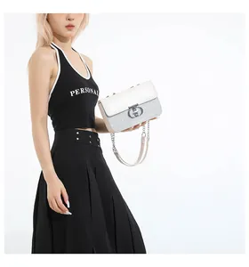 Detail of sequined shoulder bag showing silver sequins and cream leather flap closure