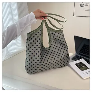 Spotted tote bag in gray-green canvas shown in a cozy home office lifestyle setting
