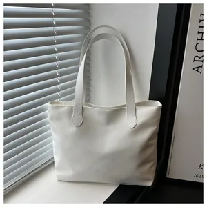 Detailed view of a minimalist white tote bag made of high-density canvas by a window