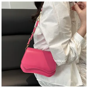 Detail of fuchsia square bag with unique double wave flap and resin chain strap