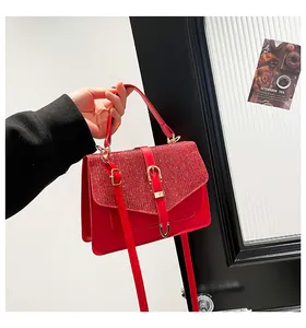 Detail einer roten Paillettenhandtasche mit Goldverschluss und verstellbarem Riemen