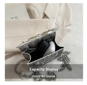 Detail showing internal capacity of snake pattern mini bag with lipstick and earbuds