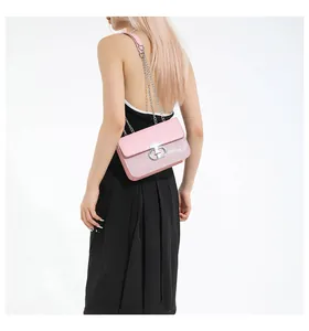 Detail of pink sequin shoulder bag with silver chain strap shown on model's shoulder