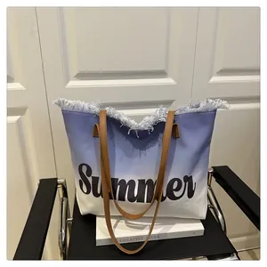 Detail of blue gradient canvas tote with Summer print and brown leather handles