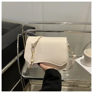 Detail of beige leather bag with unique wavy flap and chunky white acrylic chain