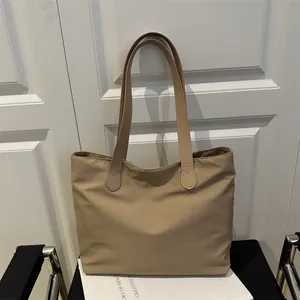 Large khaki nylon tote bag with leather handles shown on a white box for work and travel