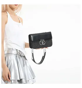 Detail of black sequin crossbody bag featuring silver ring buckle and chain strap
