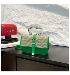 Détail du petit sac carré tressé vert avec poignée métallique argentée et bandoulière
