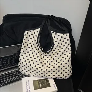 Minimalist white canvas tote bag with black polka dots for daily commuting and school