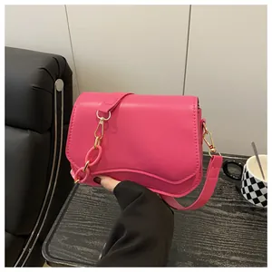 Detailed shot of pink crossbody bag featuring wavy bottom design and chunky plastic chain