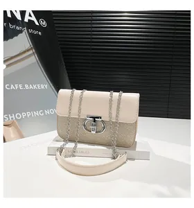 Detail of cream leather shoulder bag with textured weave and silver metal chain strap