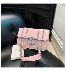 Close-up of pink sequined shoulder bag with silver CD buckle and chain strap
