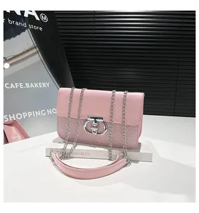 Detail of pink leather and woven fabric shoulder bag with silver round twist lock buckle