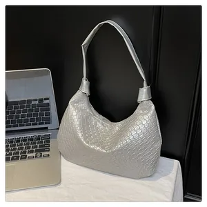 Detail of silver woven synthetic leather hobo bag showing metallic texture and grid pattern
