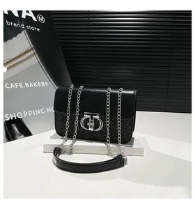 Detail of silver sequins and metal buckle on black chain shoulder bag with smooth faux leather