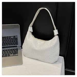 Detailed view of white woven texture hobo bag with zipper on black wooden background