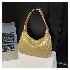 Close-up of golden woven pattern texture on a stylish tote bag with metallic luster