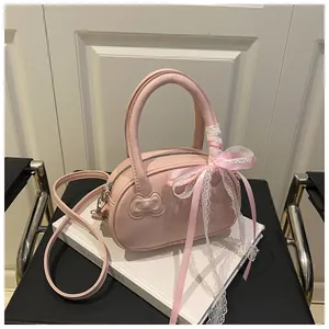 Detailed view of pink sweet-style bag with bow embossing and lace ribbon handles