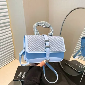 Sac chic en cuir bleu clair avec rabat tissé et poignée métallique unique