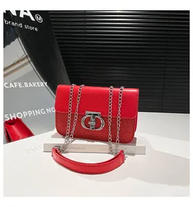 Close-up of red sequin and leather handbag featuring a silver interlocking metal buckle