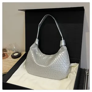 Detail of silver woven hobo bag with moon shape presented in an elegant gift box