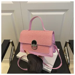 Pink faux leather and woven texture crossbody bag with round gold buckle and handle