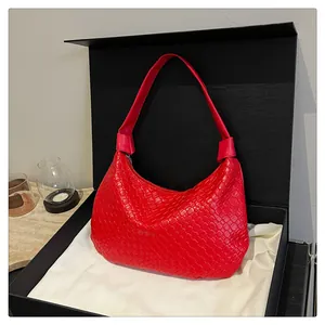 Detail of red woven texture shoulder bag in a luxury gift box with satin lining