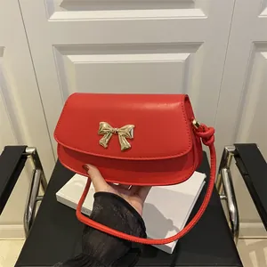 Sac bandoulière rouge moderne avec boucle nœud en métal doré et finition cuir texturé