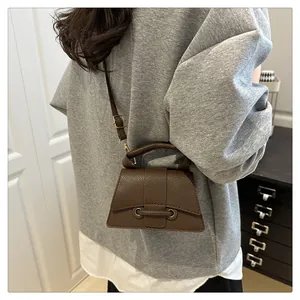 Detail shot of vintage dark brown pebble leather crossbody bag with top handle and strap