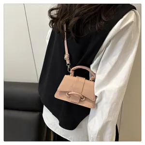Detail of pink lychee textured leather mini handbag with top handle and crossbody strap