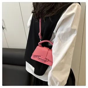 Detail of pink mini crossbody bag with litchi texture leather and metal buckle