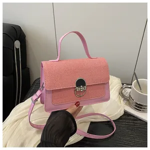 Close-up of pink crossbody bag with woven texture flap and silver metal buckle