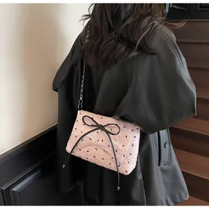 Detailansicht der rosa Jacquard-Tasche mit schwarzen Schleifen und Kettenriemen