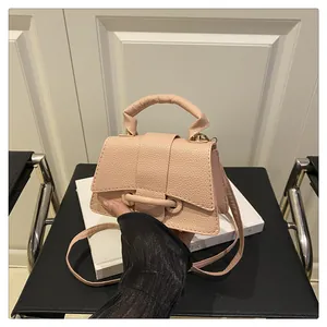 Close-up of pink litchi grain leather mini handbag with top handle and stylish metal clasp