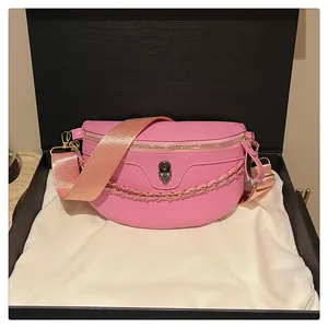 Detailed shot of pink skull embossed leather bag with gold chain in a premium gift box
