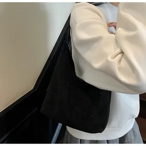 Fashionable black hobo bag with sparkling rhinestones worn as an underarm shoulder bag