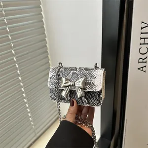 Mini snake skin crossbody bag with silver bow detail and metallic chain strap
