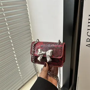 Mini snake skin crossbody bag with silver bow accent and metal chain strap for women