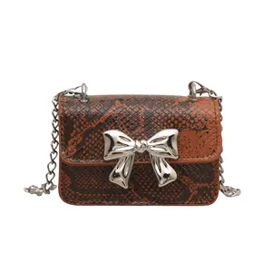 Mini snake skin leather crossbody bag with silver bow clasp and chain strap