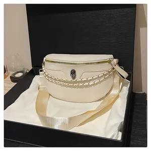 Detail of cream half-moon chest bag with skull buckle in premium gift box packaging