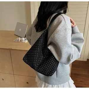 Detailed view of black rhinestone hobo bag on shoulder showing its size and soft texture