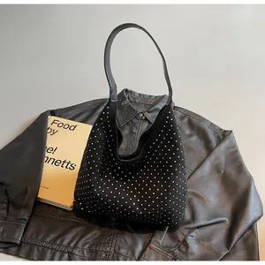 Detailed view of black hobo bag with silver rhinestones on suede-like fabric material