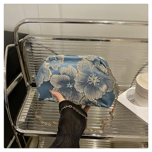 Close-up of retro floral embroidery on high-capacity satin cosmetic travel bag