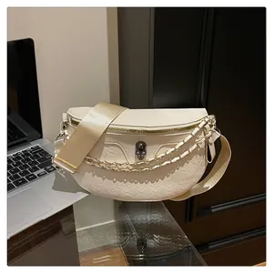 Detail of off-white crossbody bag featuring skull metal clasp and embossed textured patterns