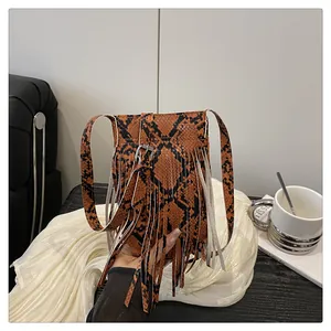 Detailed view of snake skin crossbody bag with fringes on a stylish coffee table setting