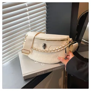 Close-up of cream leather chest bag featuring 3D skull embossing and metal hardware