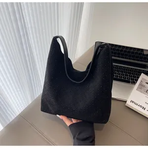 Close-up of black denim hobo bag featuring tonal stud details and a soft matte texture