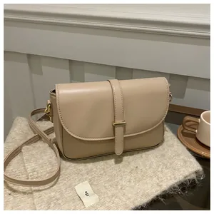 Chic beige leather shoulder bag displayed on cozy knitwear with elegant coffee decor