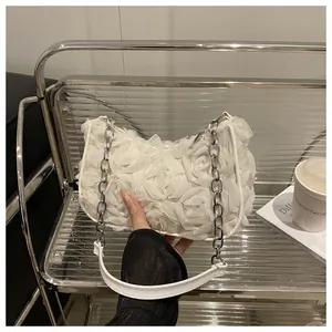 Détail du sac à bandoulière en maille avec fleurs 3D et chaîne en métal argenté