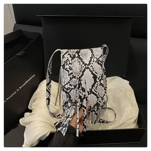 Close-up of black and white snakeskin print bag with long fringe in a gift box